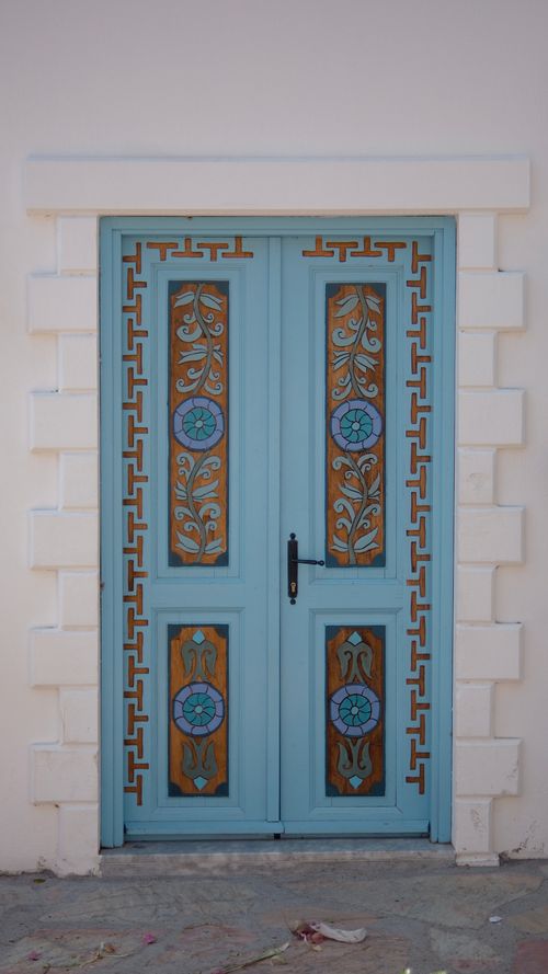 Free A beautifully ornate blue door featuring intricate geometric and floral patterns. Stock Photo
