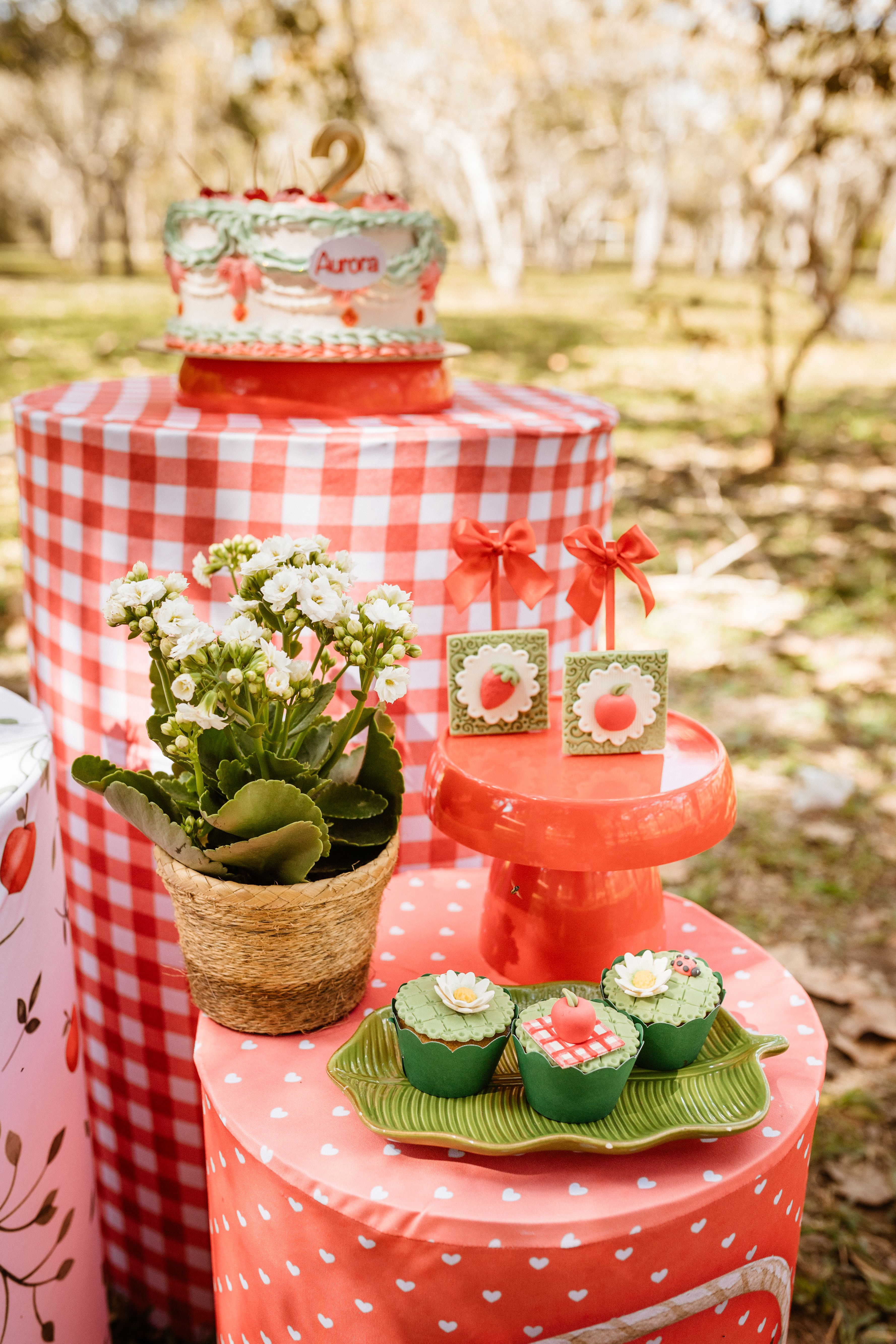 Milestone birthday decor ideas with a birthday cake and cupcakes displayed on outdoor tables