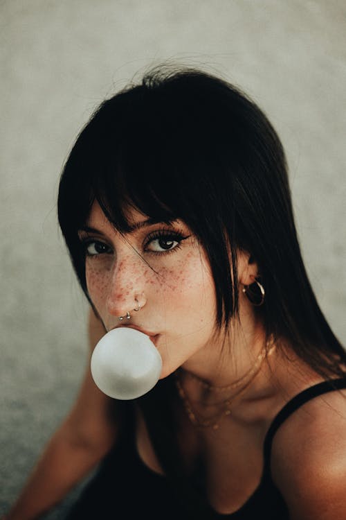 Young Brunette Blowing Gum Bubble
