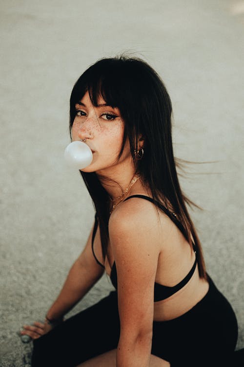 Young Woman Blowing Gum Bubble on Beach