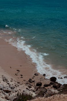 Peaceful beach scene with gentle waves on a sunny day, capturing the essence of summer relaxation.