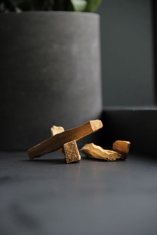 Free Aromatic Palo Santo sticks placed on a dark table, ideal for spiritual rituals. Stock Photo