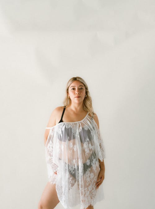 Young Woman in Lingerie Posing near White Wall