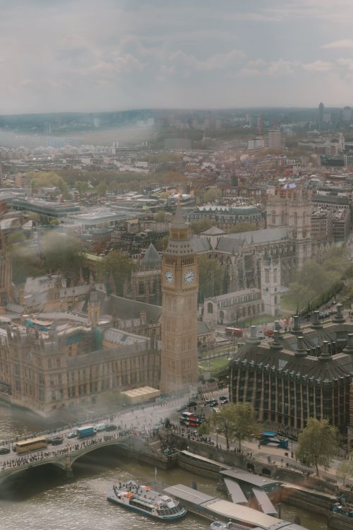 Free A captivating aerial view of Big Ben and the Thames River in London on a cloudy day. Stock Photo