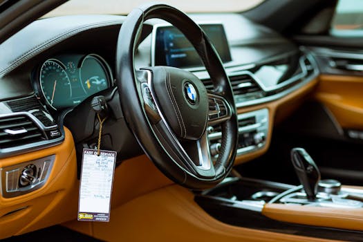 Upscale car interior showcasing the steering wheel, console, and dashboard in detail.