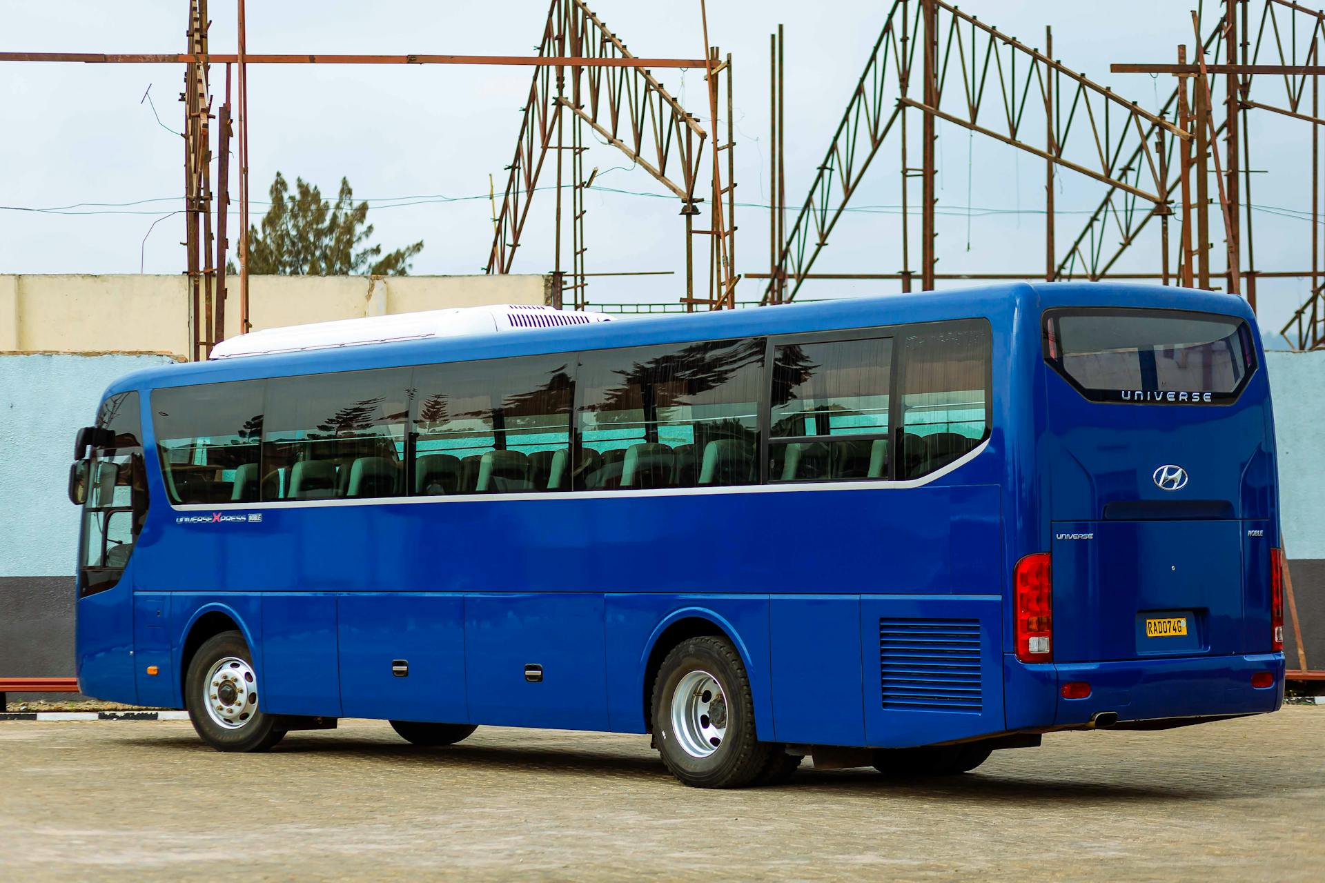 Side view of a blue Hyundai bus parked in an outdoor lot, showcasing modern design.