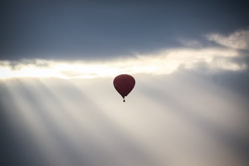 Hot Air Balloon Flying against Sunbeams