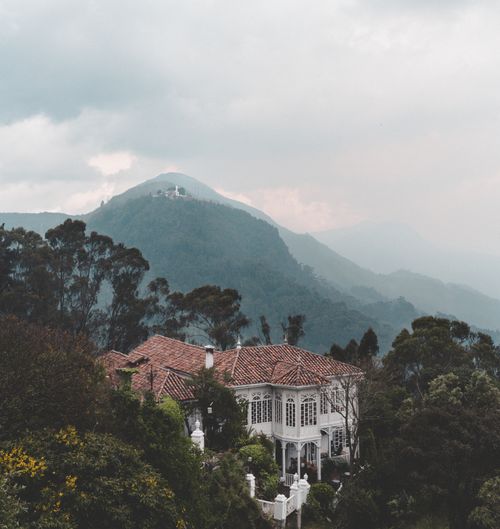 Free Charming villa surrounded by lush forest and misty mountains, offering luxury and tranquility. Stock Photo