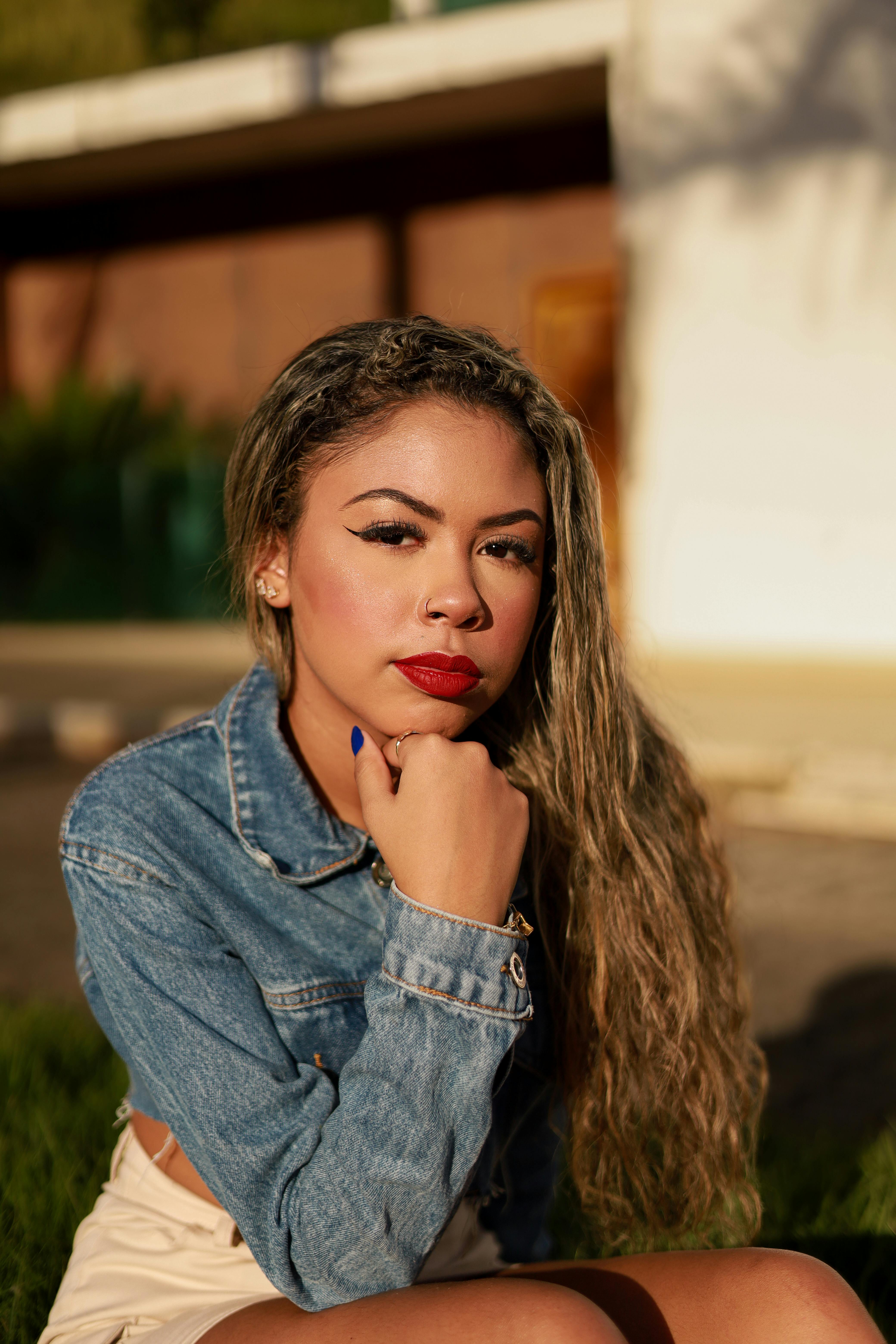 Portrait of a woman in a denim jacket outdoors, showcasing thoughtful expression.