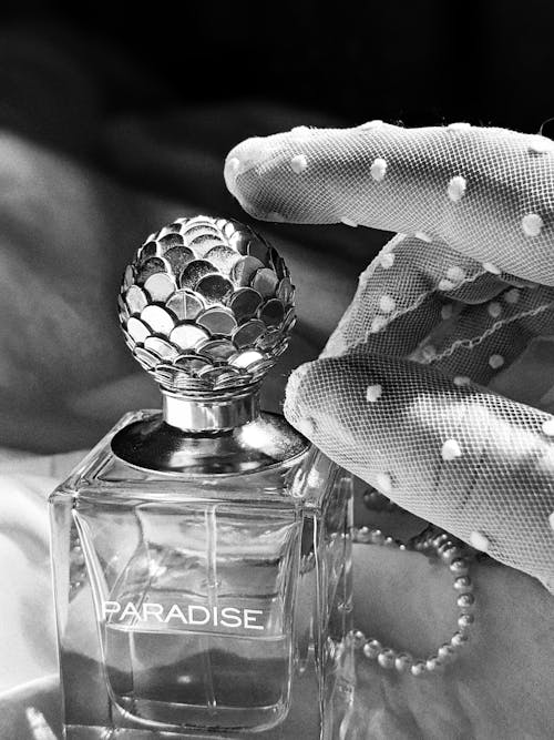 Hand Reaching for a Luxury Perfume Bottle