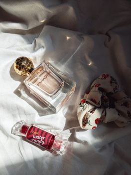 Luxury perfume and cosmetic product on soft fabric with elegant lighting.