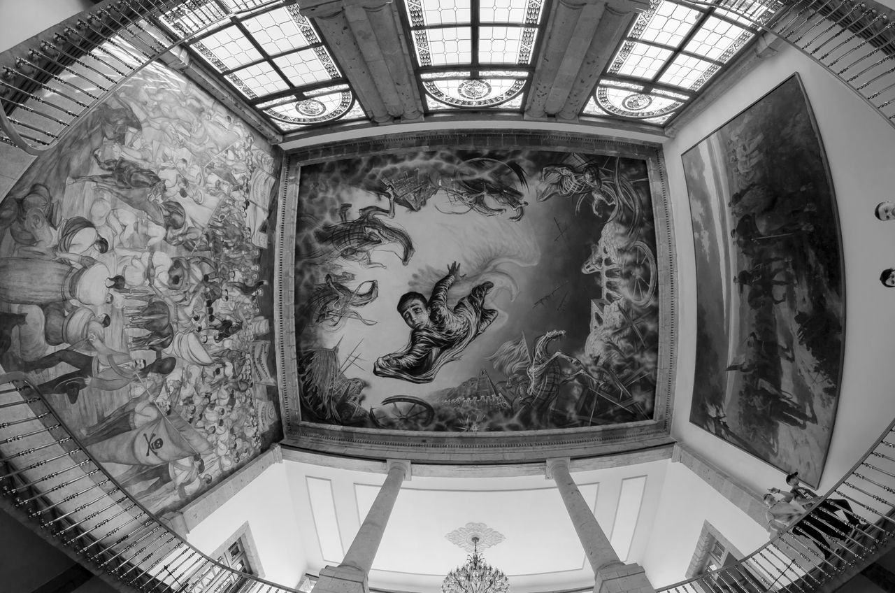 black and white interior with historical murals on ceiling and walls
