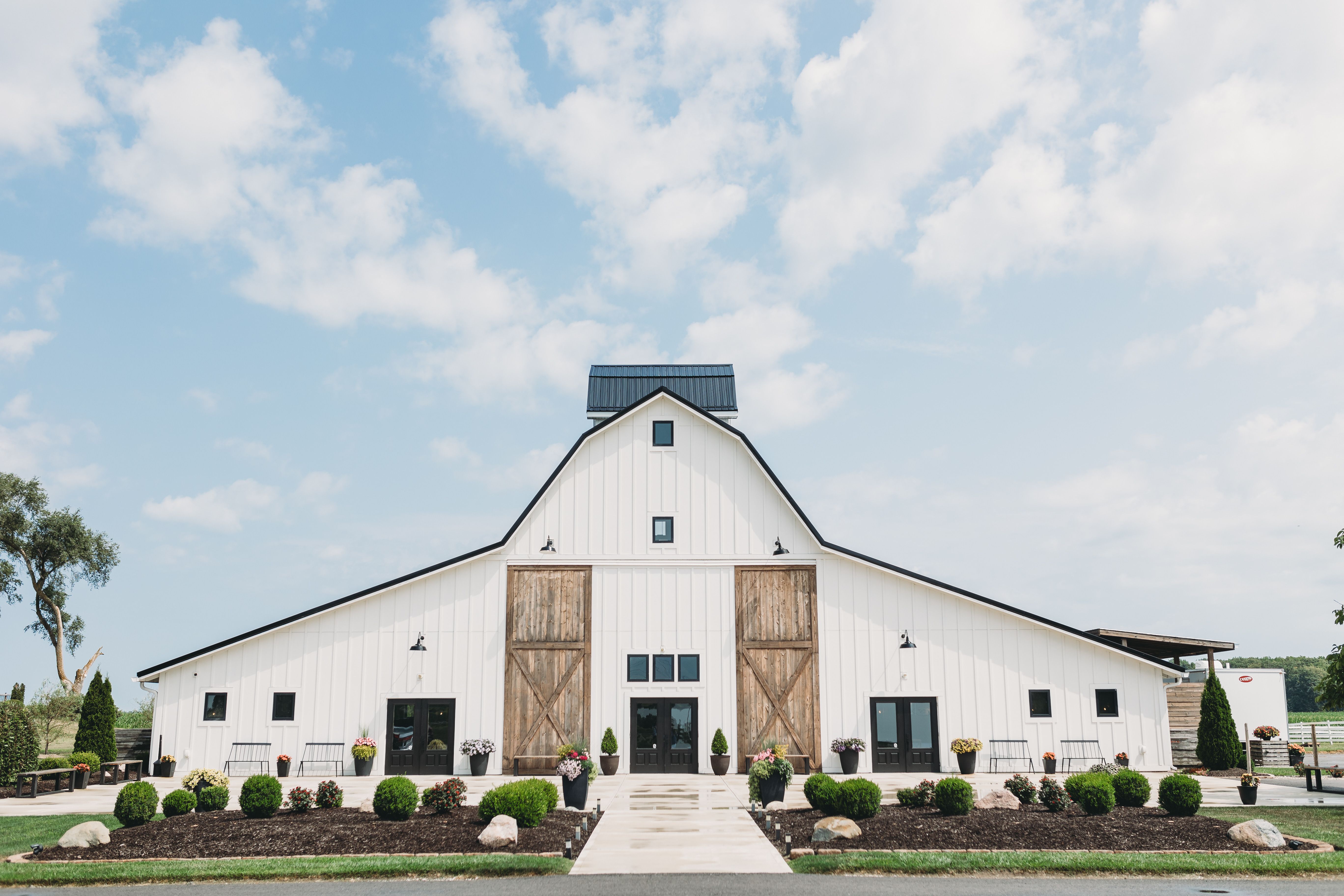 Charming white barn under a clear blue sky for a rustic wedding celebration