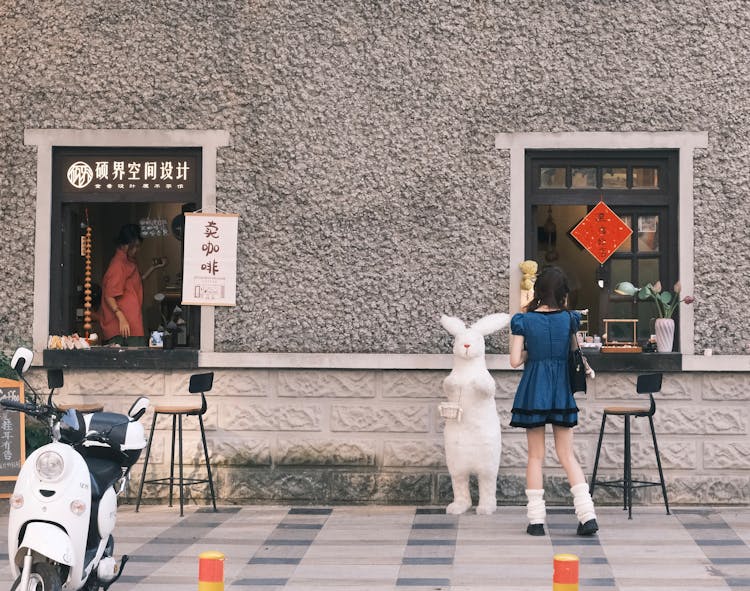 Girl Standing Near Traditional Asian Shop In Building 