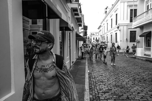 A vibrant black and white city street scene with people walking.