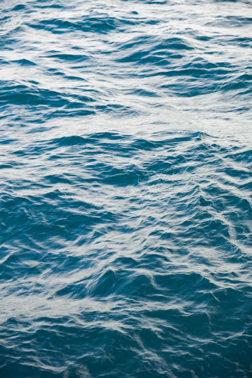 Free A peaceful view of gentle ocean waves rippling in blue tones, capturing a serene aquatic mood. Stock Photo