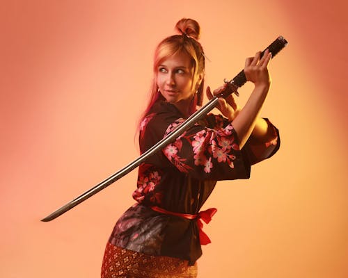 Woman in a Costume Posing with a Samurai Sword