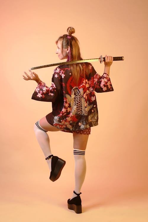 https://images.pexels.com/photos/18035048/pexels-photo-18035048/free-photo-of-woman-in-a-kimono-and-a-samurai-sword.jpeg?auto=compress&cs=tinysrgb&dpr=1&w=500