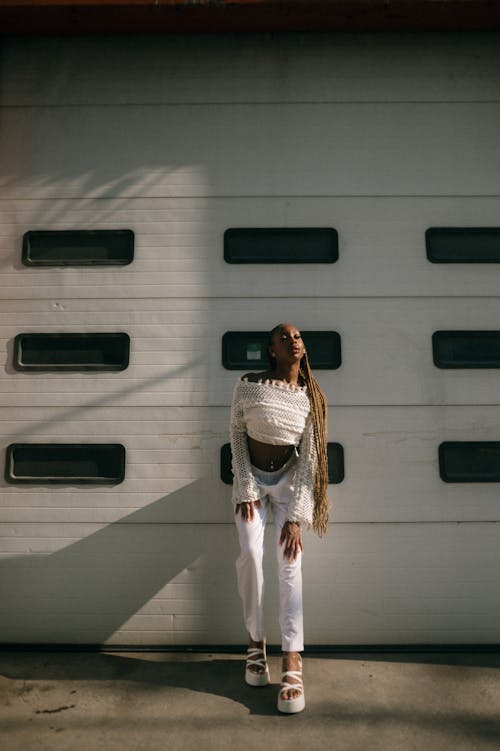 Young Fashionable Woman Standing in front of Garage Doors 