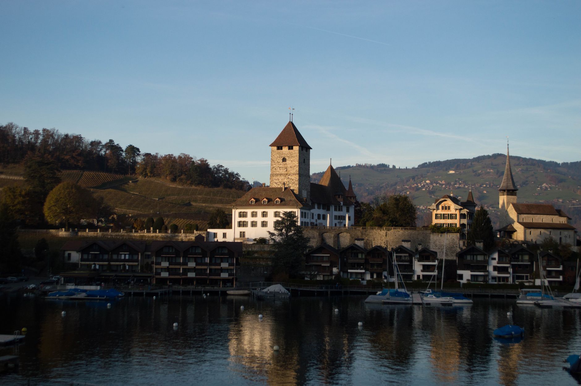 Beautiful view of Thun Castle by the lake in Switzerland with mountains in the background.