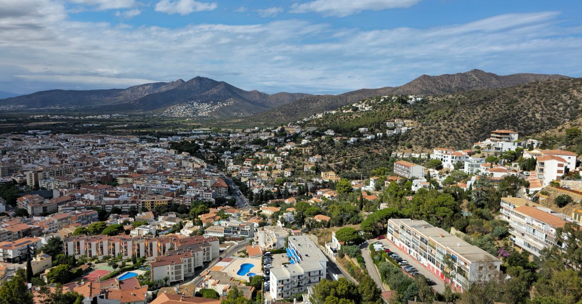 Stunning aerial view of a Mediterranean town surrounded by hills and mountains.
