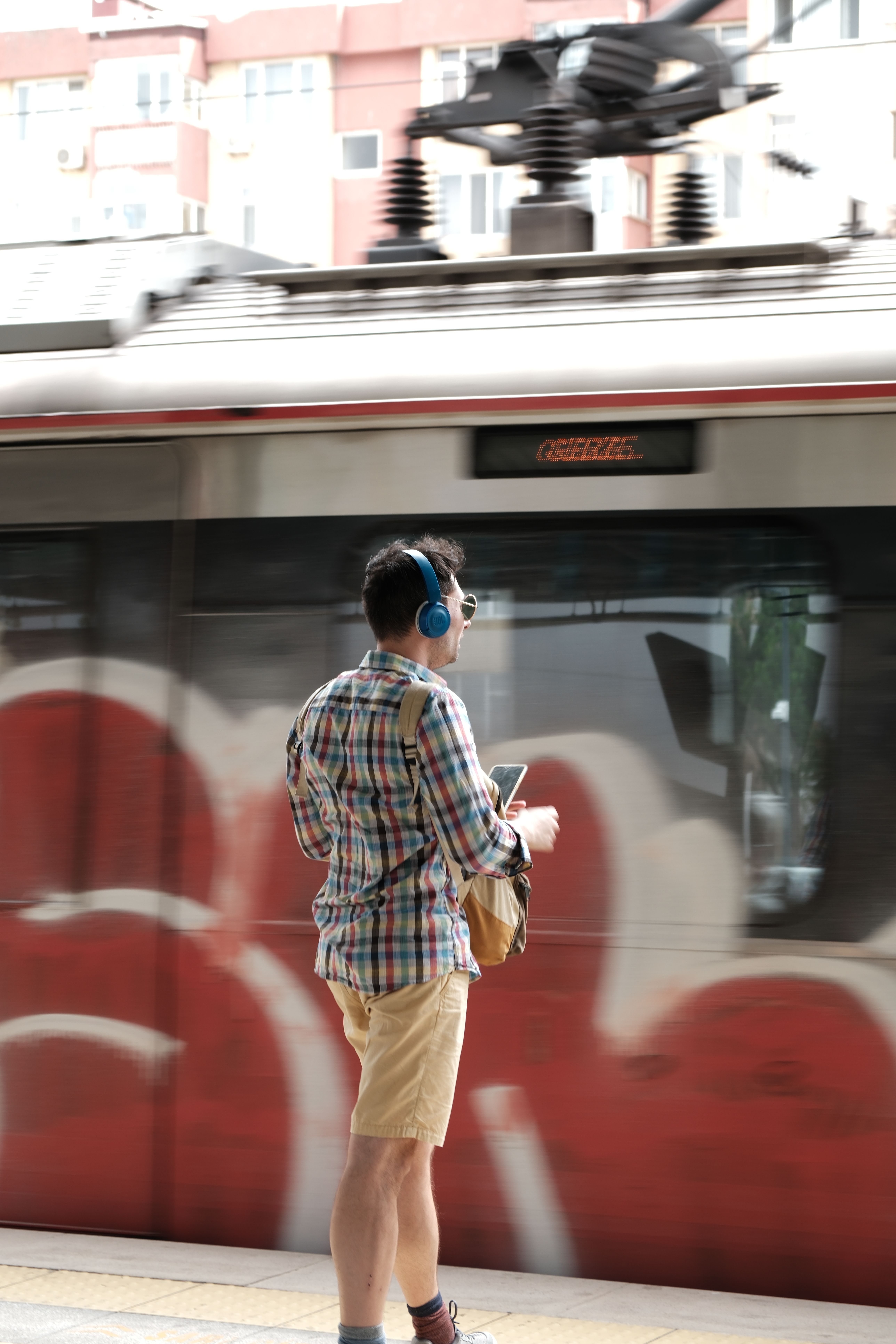 A Man with Headphones Standing on the Tram Stop · Free Stock Photo