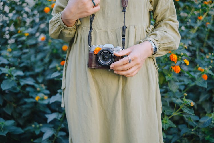 Woman In A Dress And A Film Camera Hanging On Her Neck 