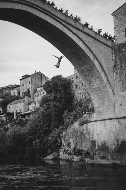 A thrilling dive from Stari Most bridge in Mostar, Bosnia, showcasing Ottoman architecture.