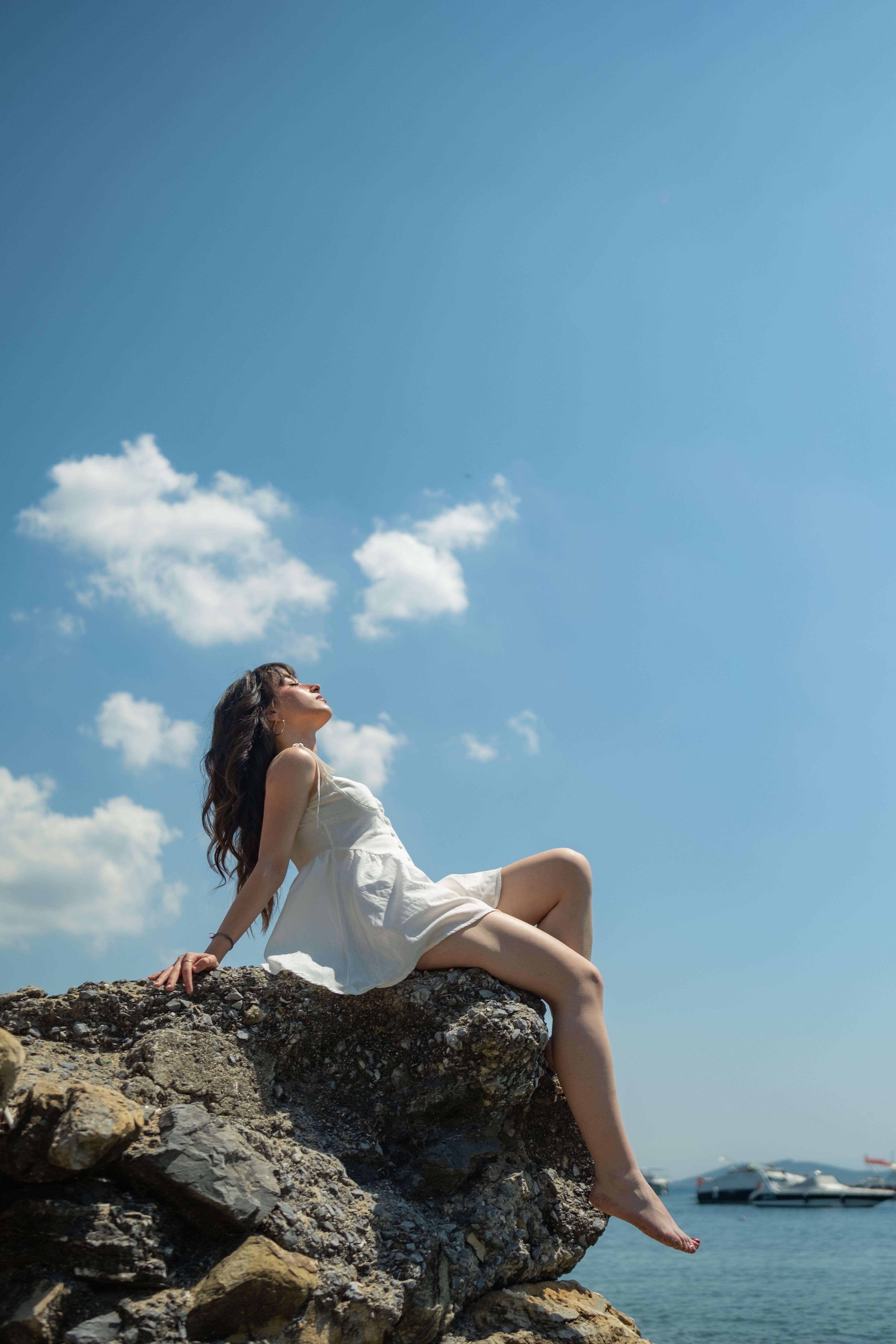 Woman in Dress Sitting on Rock near Water · Free Stock Photo