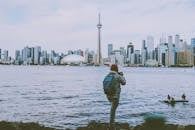 Back View of a Man with a Backpack Standing on the Background of Toronto