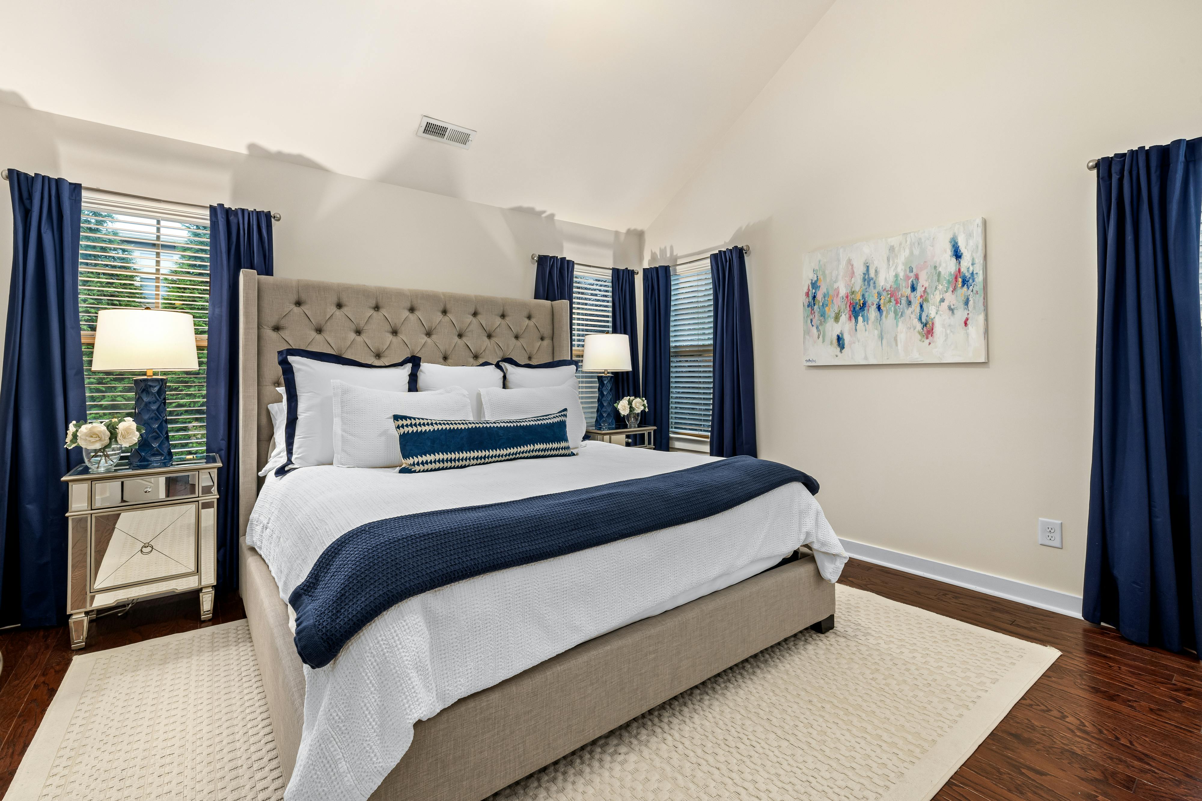 big bed with white and blue color linen in the middle of the bedroom 