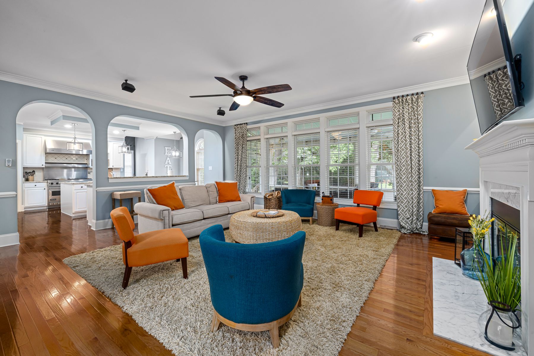 Open apartment living zone softened by a large rug and upholstered furniture