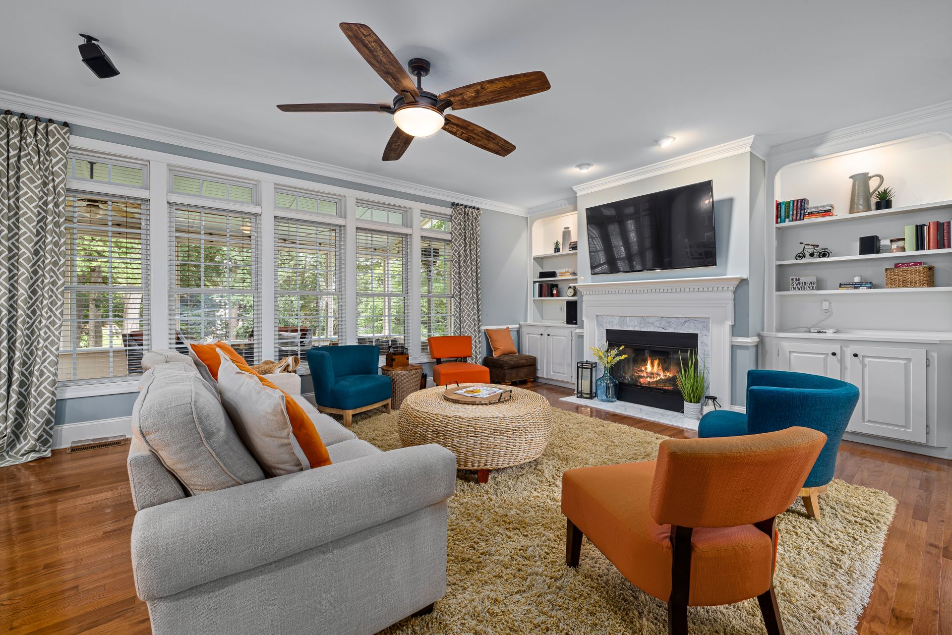 A stylish living room featuring colorful armchairs, a fireplace, and elegant decor.
