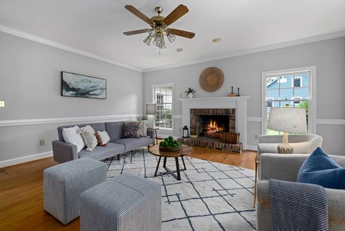 Free Cozy living room with modern furniture and a lit fireplace, perfect for relaxing evenings. Stock Photo