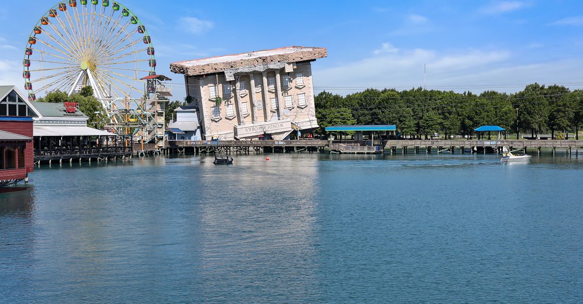 View of the iconic upside-down Wonder Works building and Ferris wheel at Myrtle Beach waterfront.