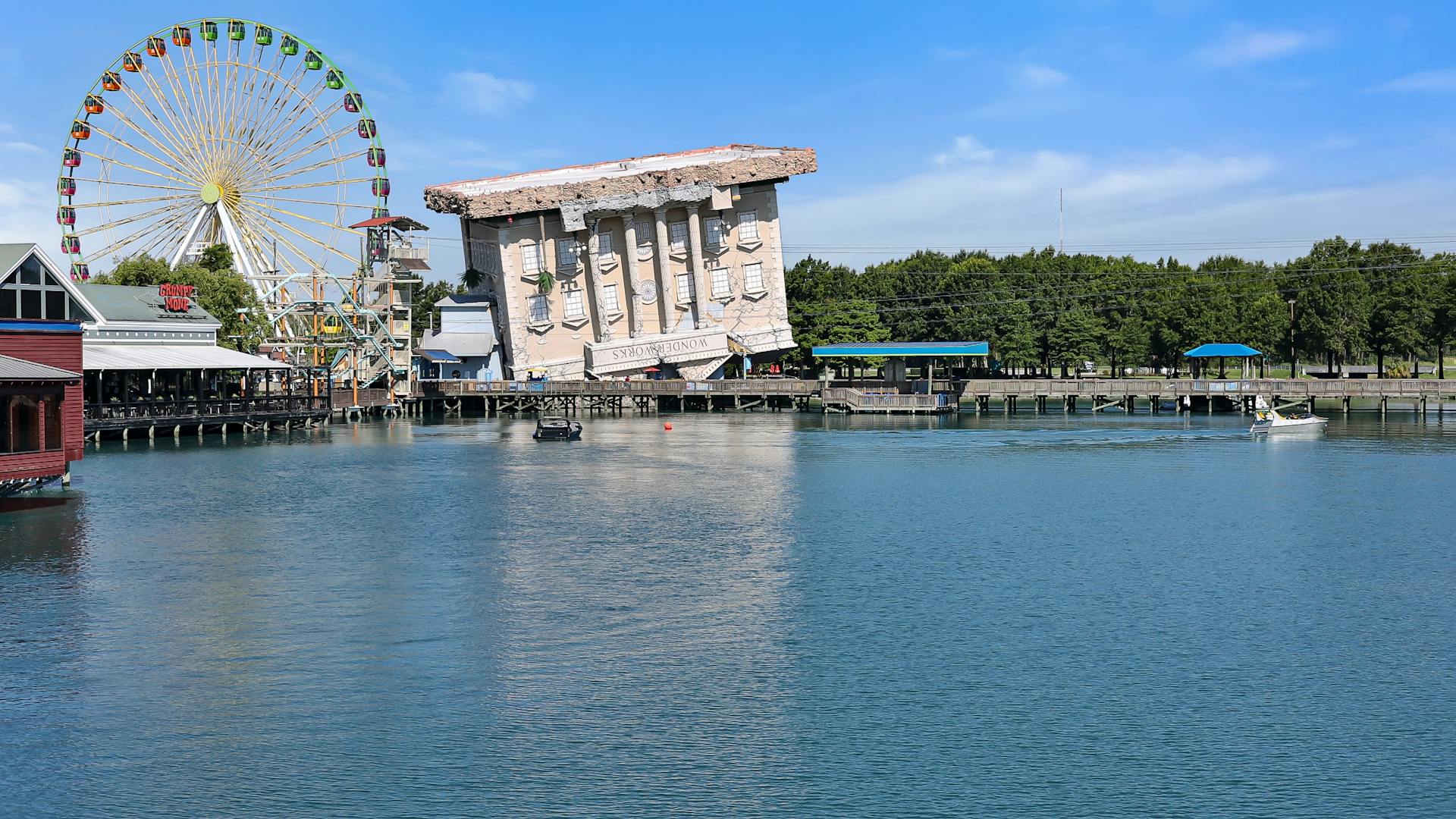 View of the iconic upside-down Wonder Works building and Ferris wheel at Myrtle Beach waterfront.