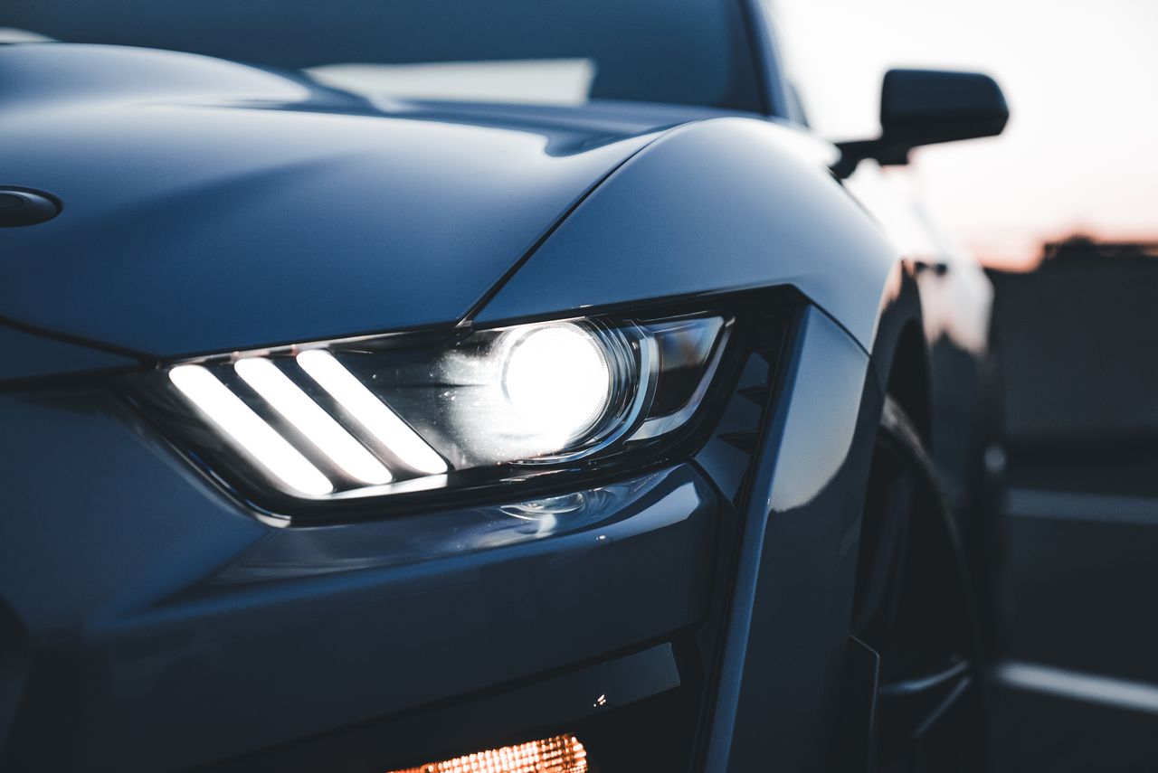 dramatic close up of a car s headlight during sunset highlighting its
