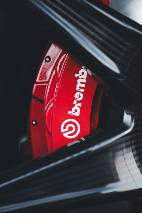 Free Detailed shot of a red Brembo brake caliper with carbon fiber components. Stock Photo