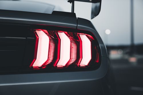 Free A sleek sports car taillight with illuminated red lights, creating a modern and dynamic aesthetic. Stock Photo