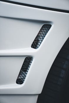 Close-up view of a modern white car's sleek design and detail.