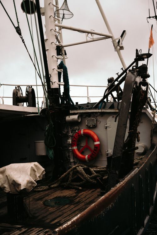 Free Explore the rugged deck of a fishing trawler under overcast skies, showcasing maritime equipment. Stock Photo