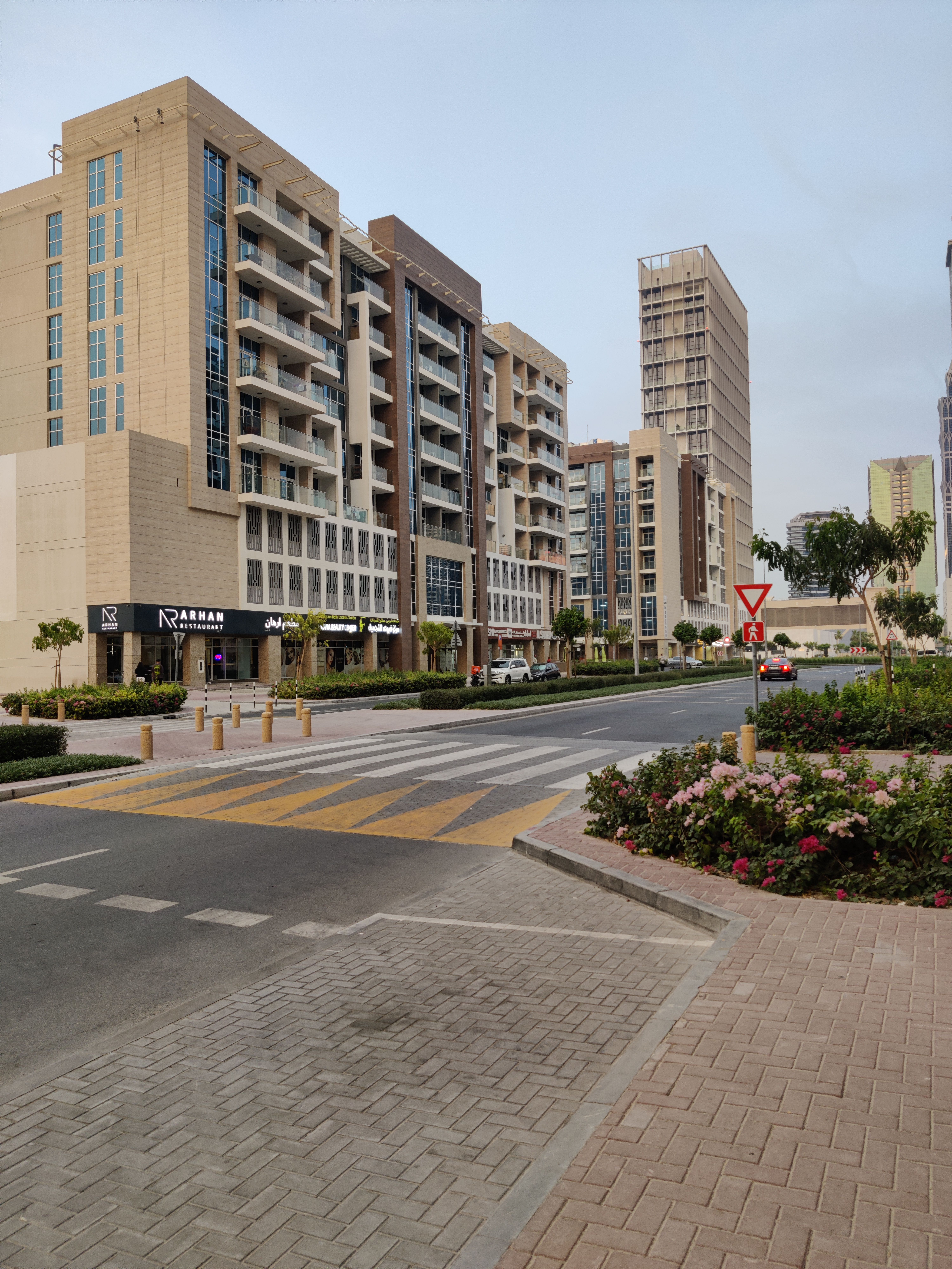 Street view of modern residential buildings and crosswalk in urban area.