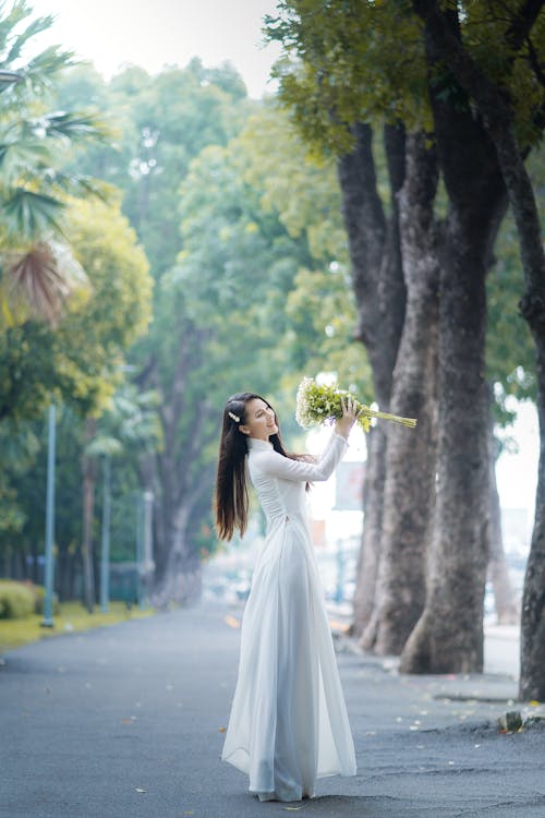 Smiling Woman Standing on Street with Bouquet