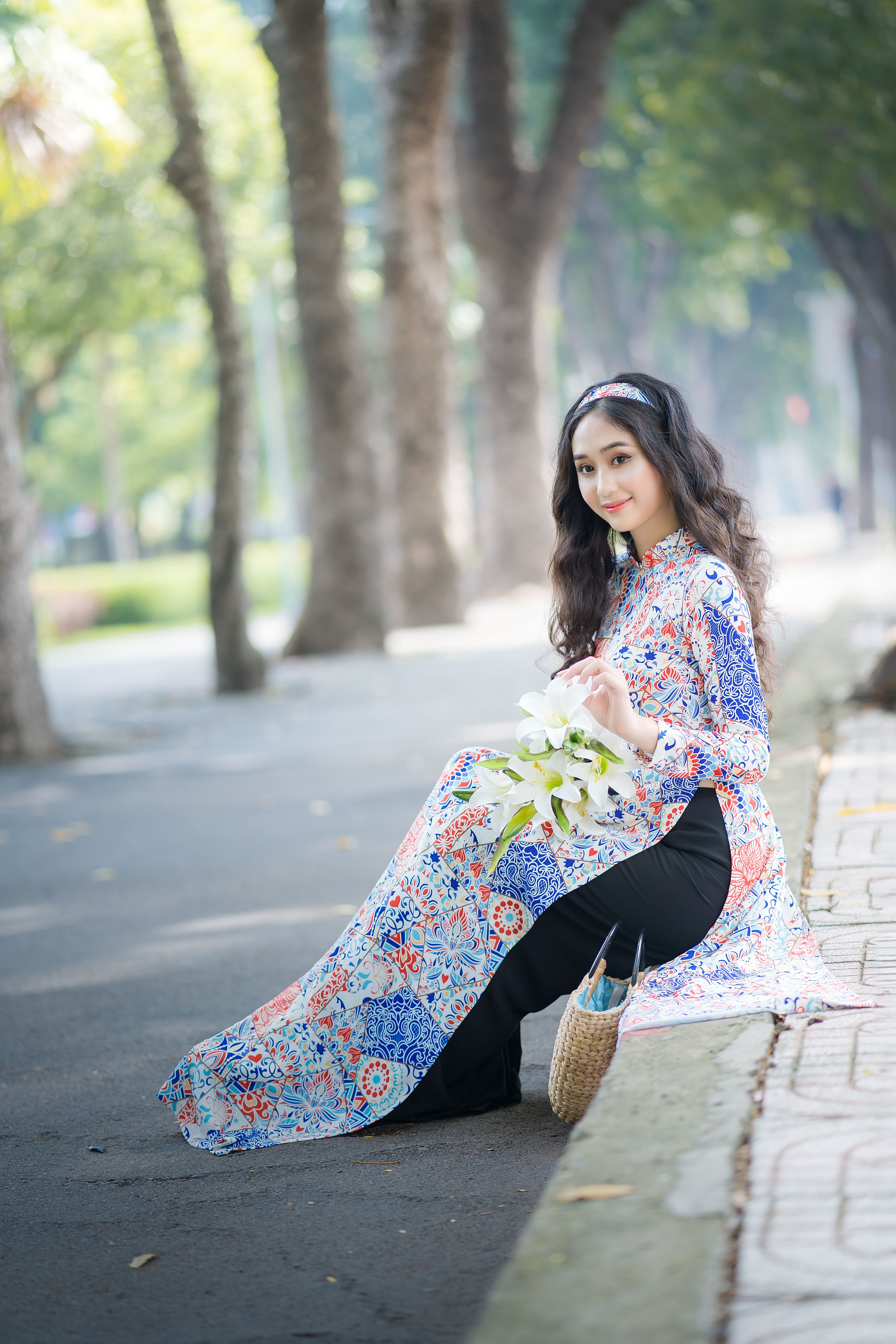 Young Woman in Traditional Dress Sitting on Sidewalk · Free Stock Photo