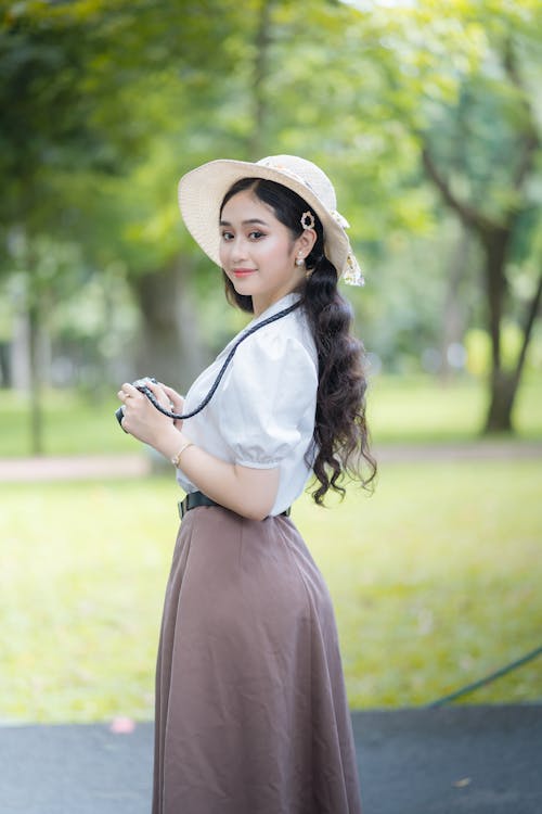 Young Elegant Woman Standing in a Park 