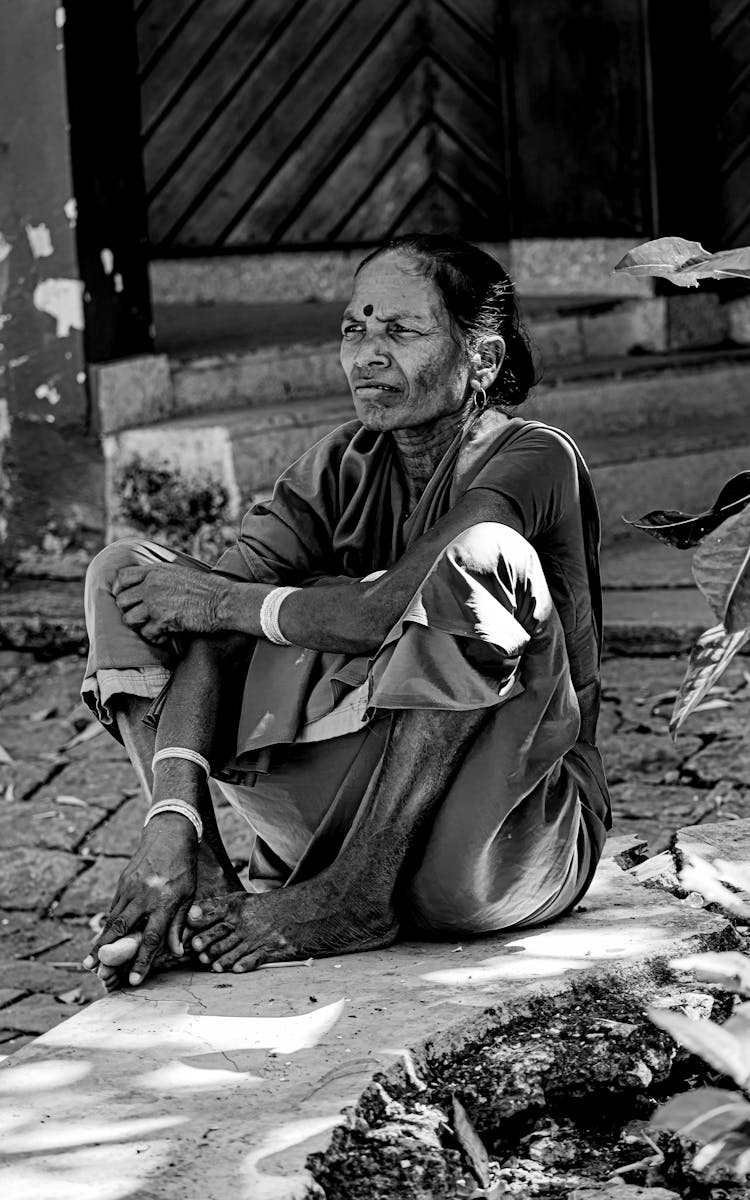 Old Indian Woman Sitting On Ground