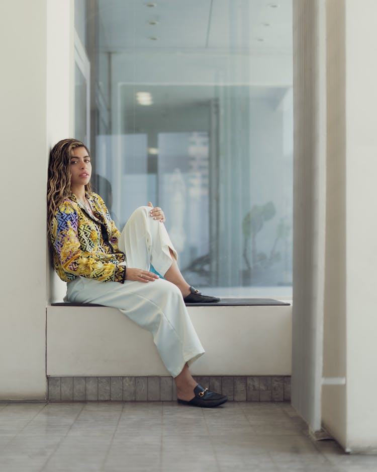 Woman Posing On Wall Near Window