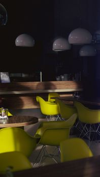 Modern cafe interior featuring vibrant green chairs and stylish pendant lamps.