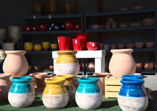 Free Vibrant ceramic pots in diverse colors on display outdoors in a pottery shop. Stock Photo