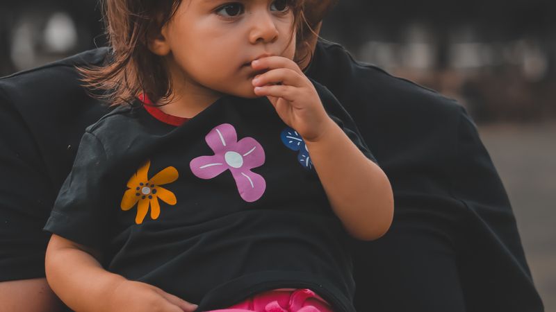 A father lovingly holding his daughter in a park, capturing family moments.